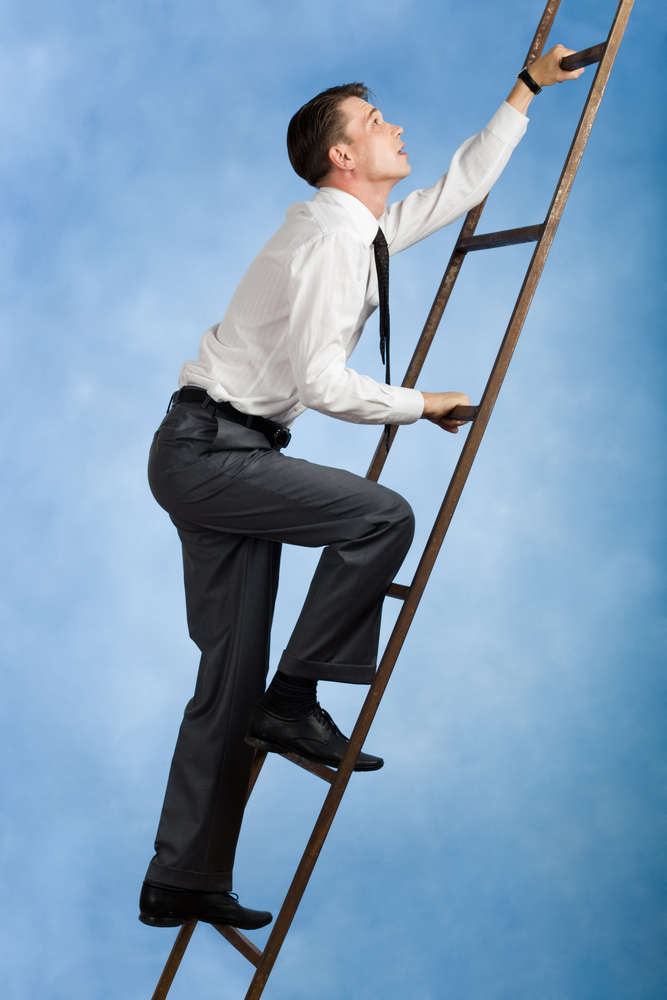 Young Businessman Climbing Ladder Upwards | Shutterstock.com